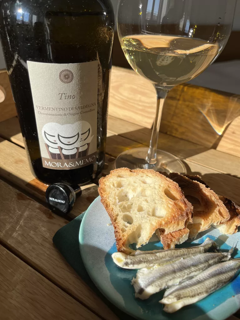 Un verre de Tino, Vermentino di Sardegna Doc, trois anchois et deux tranches de pain grillées.